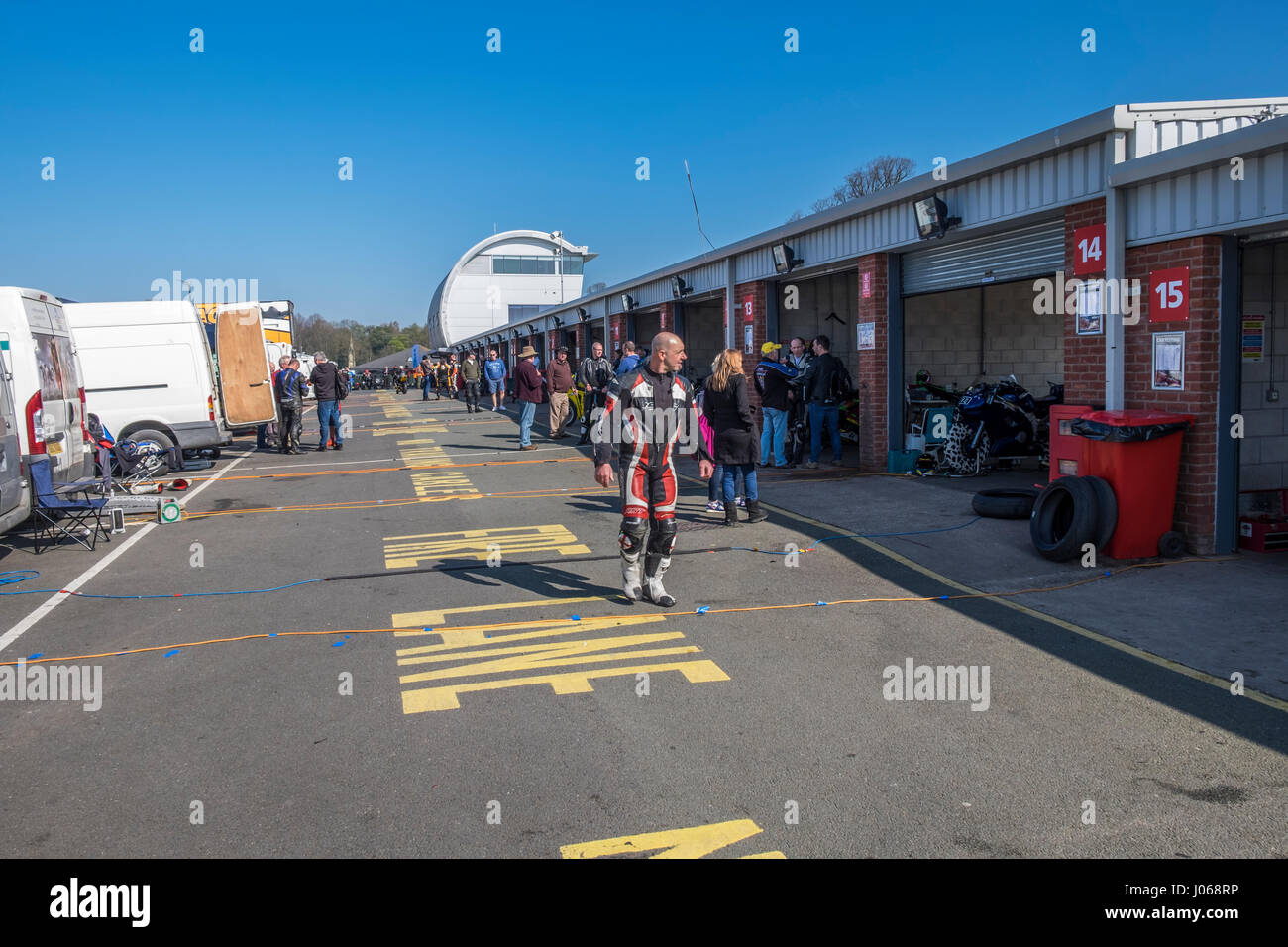 Motorbike rider walking down the pit lane at racing circuit, Stock Photo