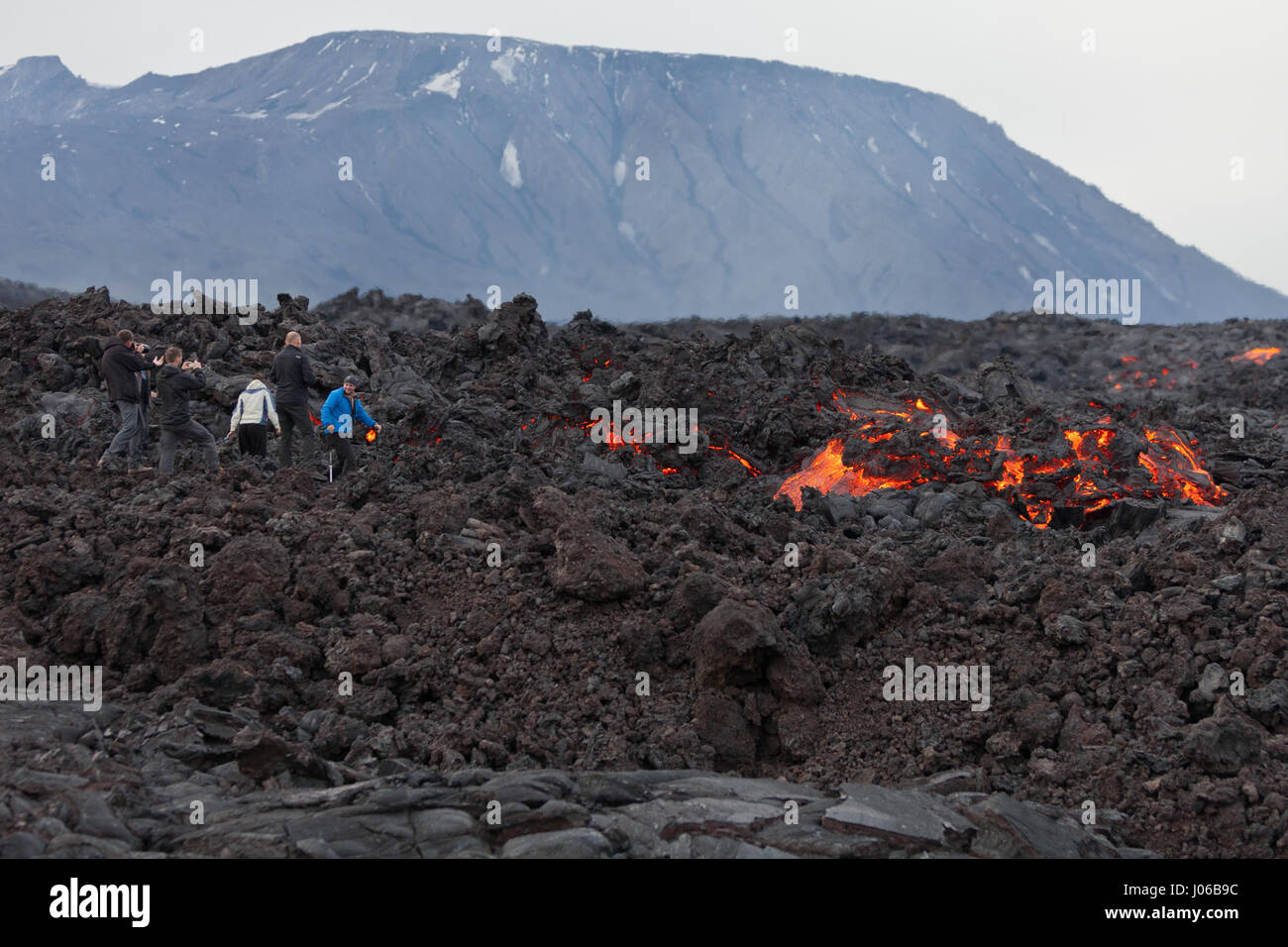 KAMCHATKA PENINSULA, RUSSIA: LOOKING like they are standing on hot coals these shots show fearless lava-lovers only ten feet away from the mouth of an active volcano. Perilously close to the action these adventurers, can be seen posing near glowing molten lava which can reach temperatures of 1,200 degrees Celsius. Russian photographer Sergey Krasnoshchekov (49) was able to snap this natural phenomenon unfolding at Tolbachik volcano in the Kamchatka peninsula, Russia. Stock Photo
