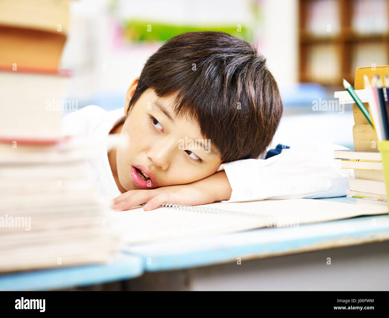 asian elementary schoolboy tire and resting head on desk. Stock Photo