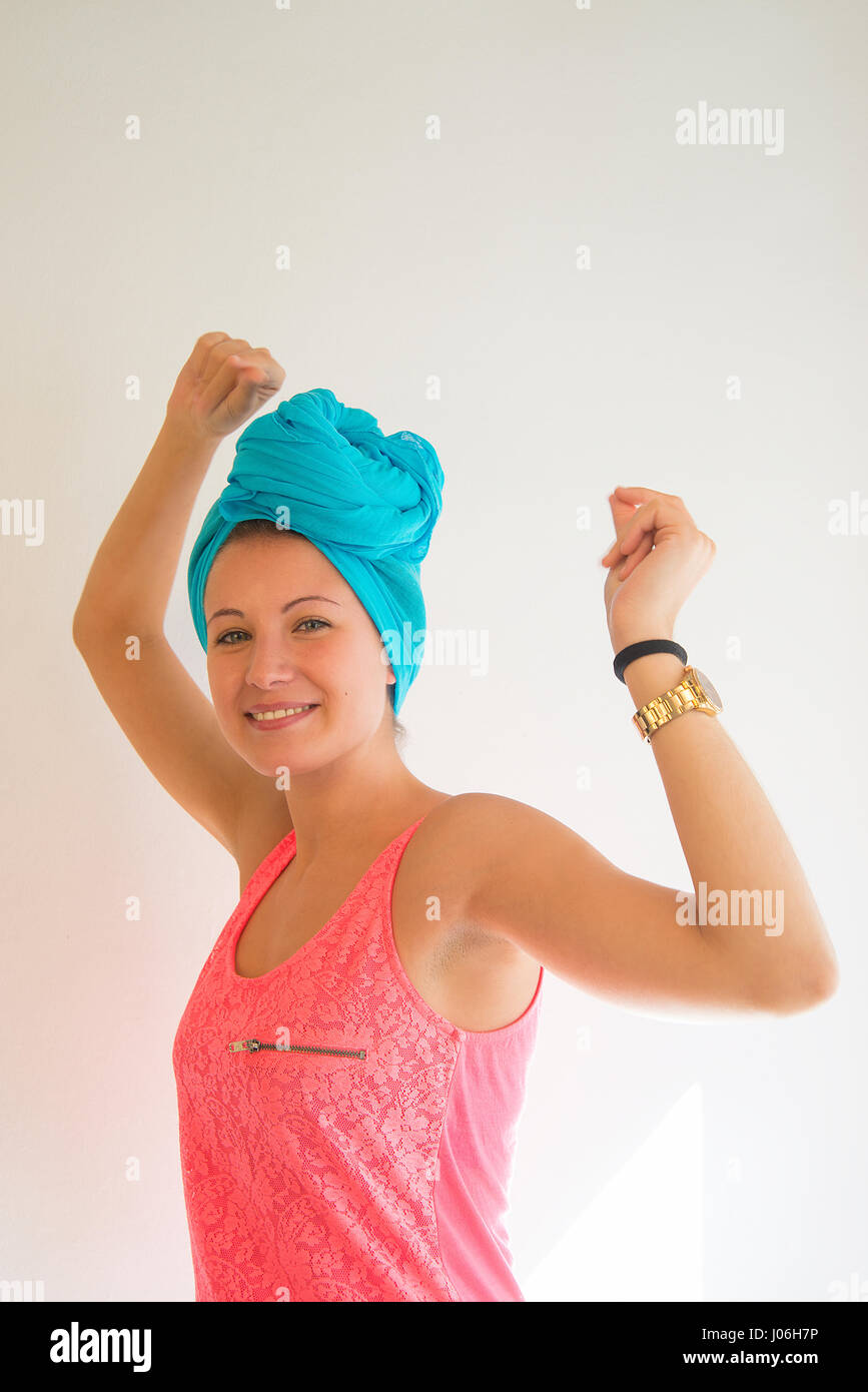 Young woman wearing turquoise turban and pink top, expressing happiness. Stock Photo