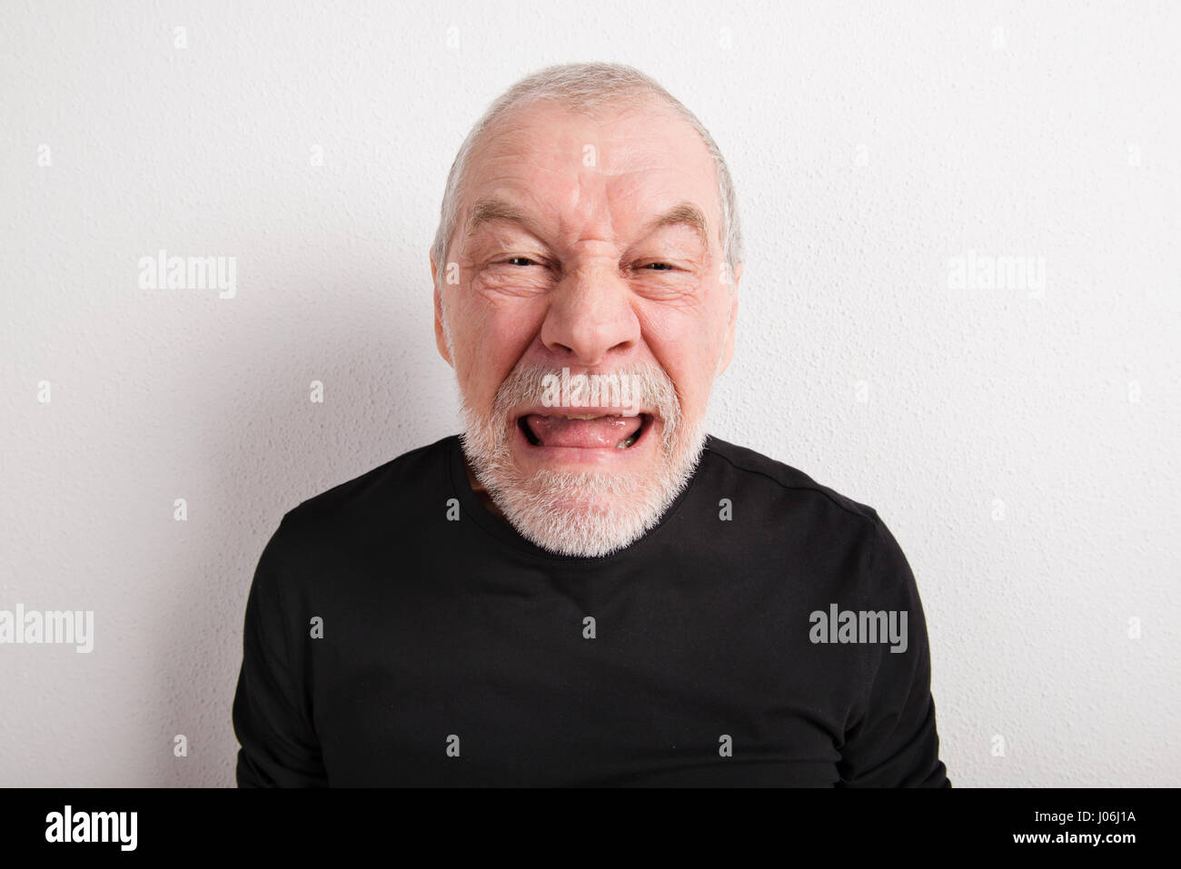Senior man making funny face, studio shot. Stock Photo