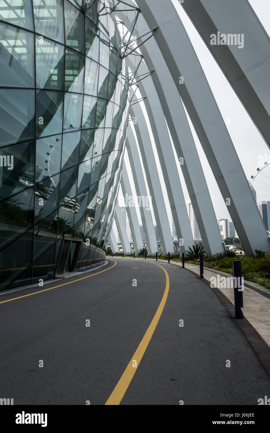 Empty road curving around the Singapore Flower Dome under the supporting white columns. Stock Photo