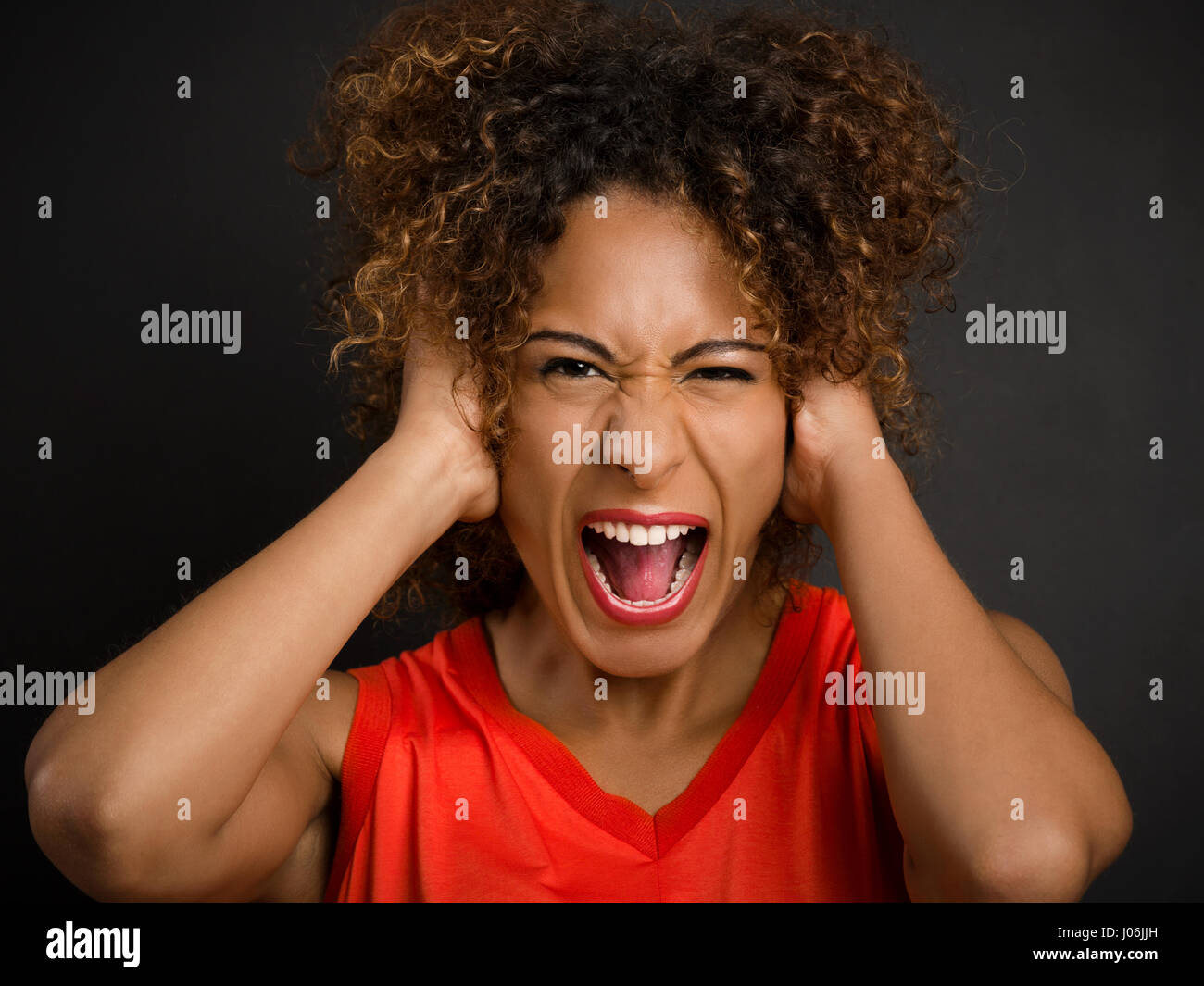 Portrait of an African American woman with hands on the head and yelling Stock Photo