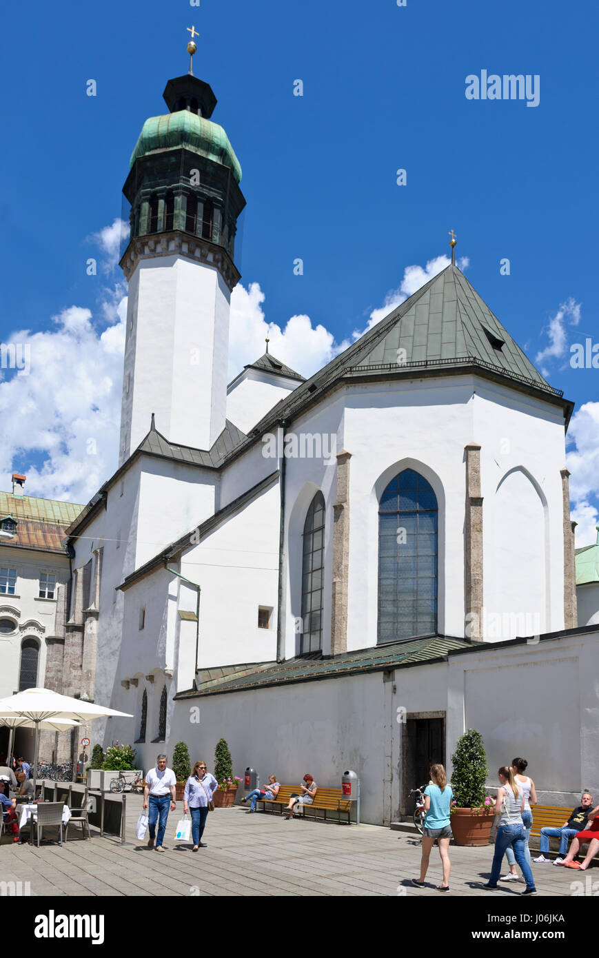 People eating and drinking under large umbrelas in the square by the