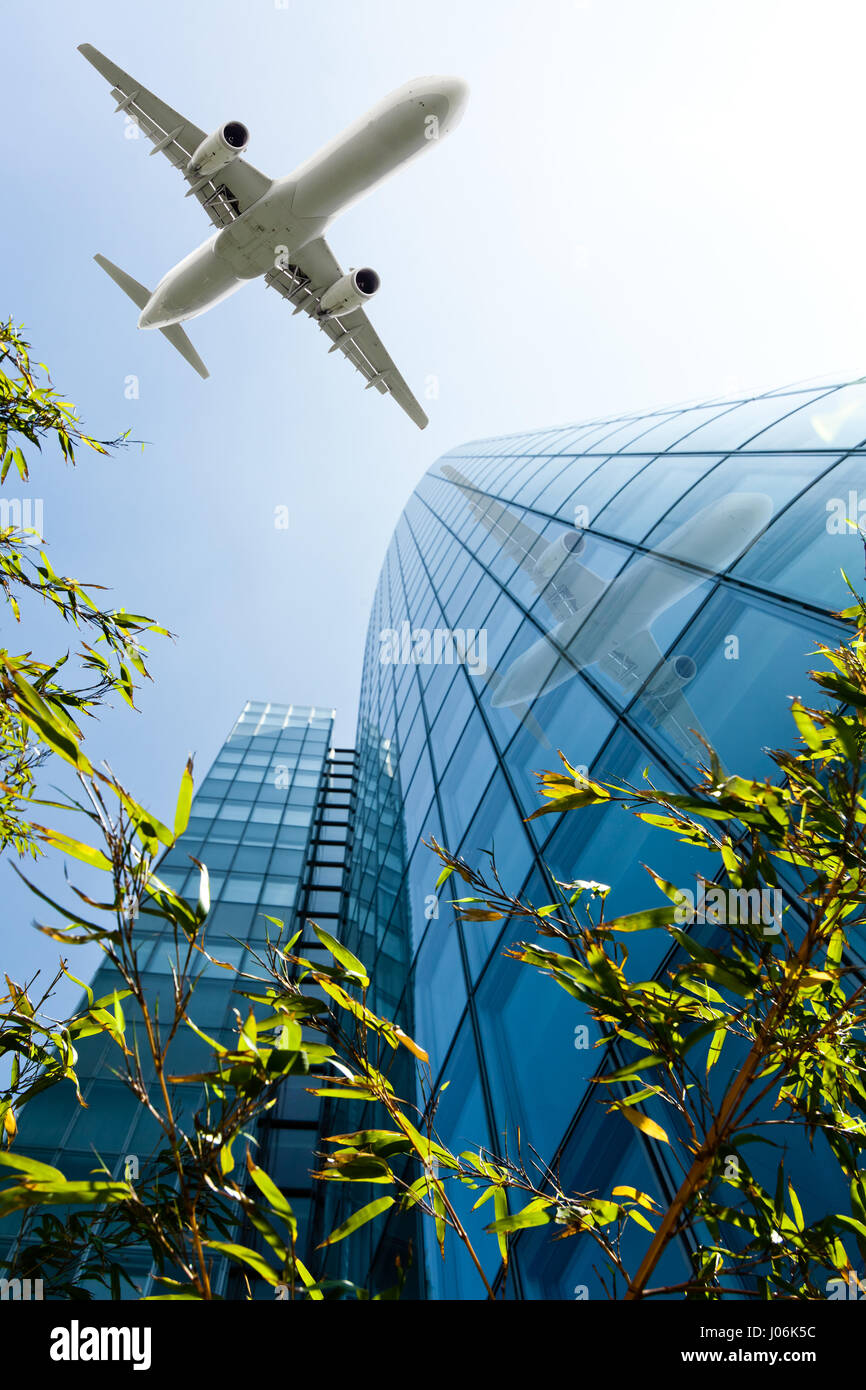 Skyscrapers with a flying airplane against blue sky Stock Photo - Alamy