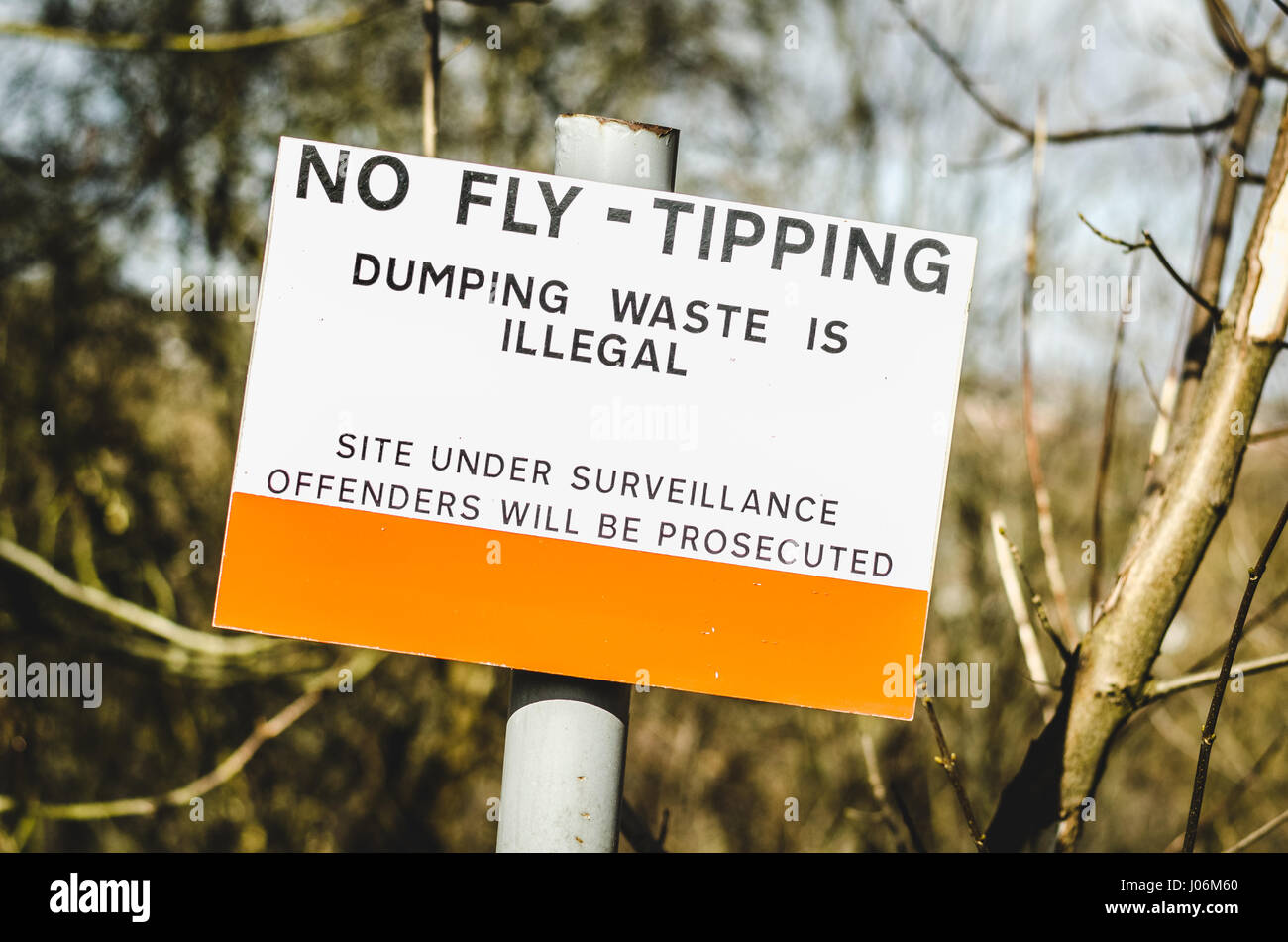 A sign in England, UK warning that dumping of trash in the area is illegal and offenders will be prosecuted. Surveillance site. Stock Photo