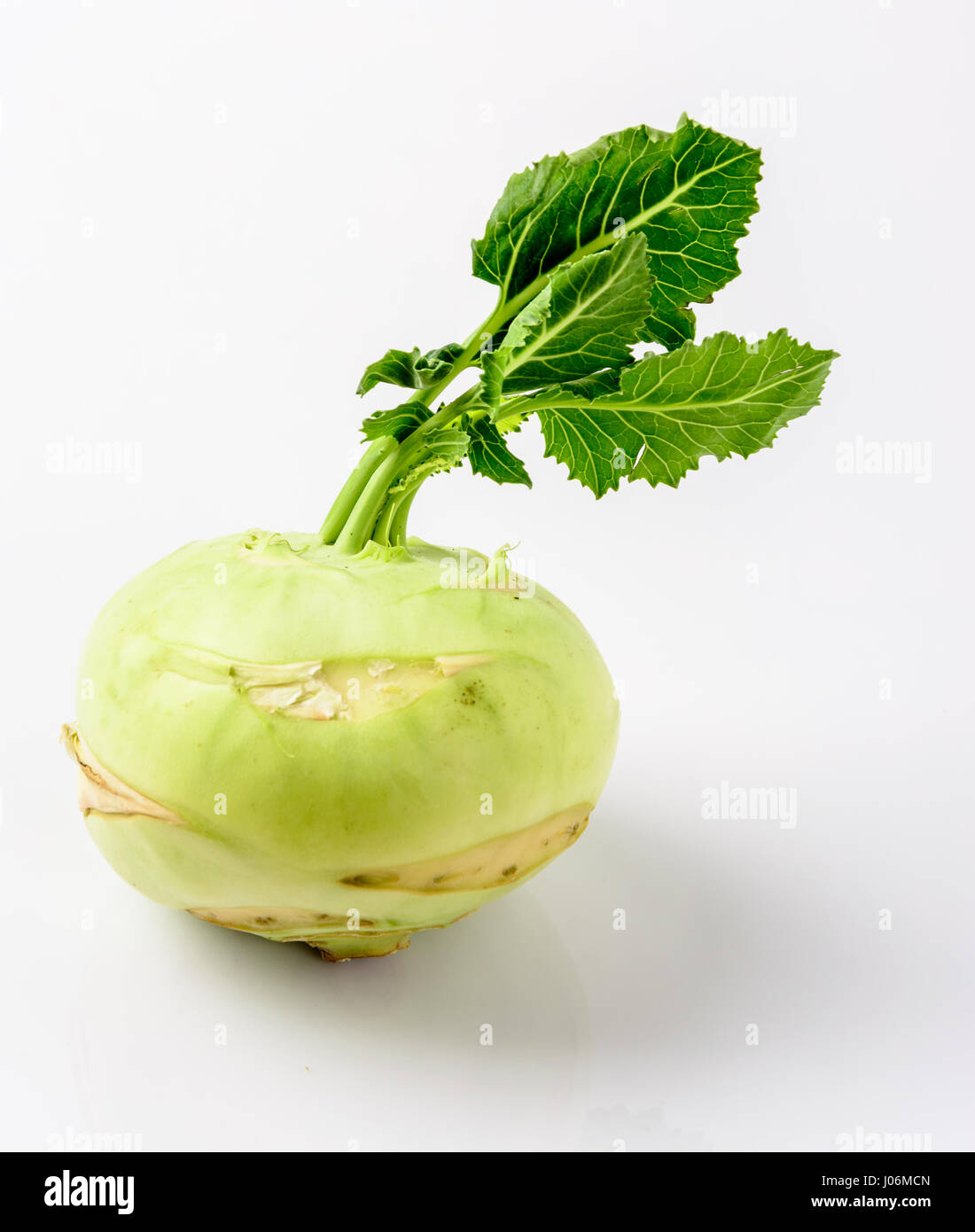 Fresh kohlrabi with green leaves on  white background. Stock Photo