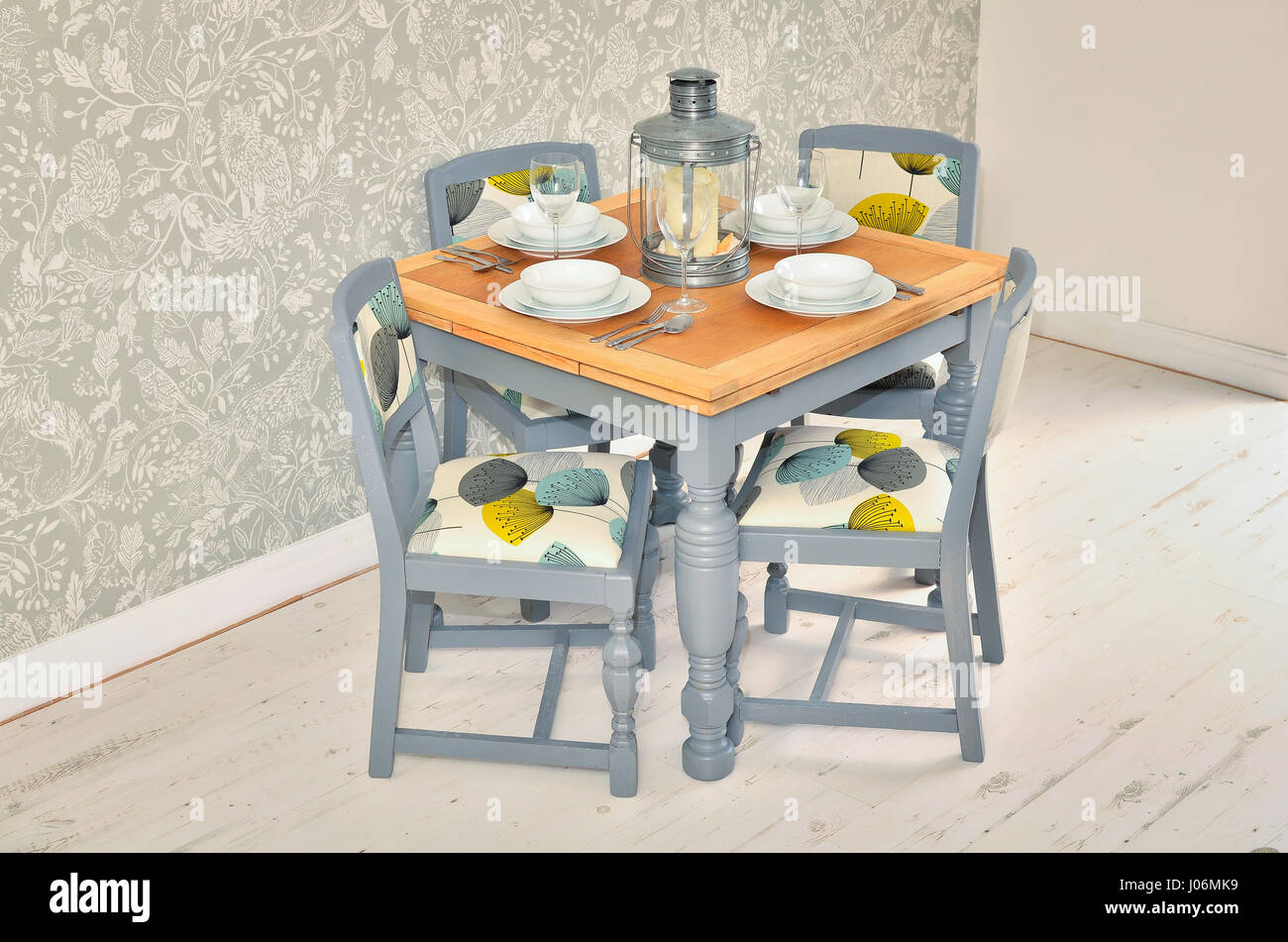 Dining table with chairs, plates, bowls and cutlery. Shabby chic dining room interior. Stock Photo