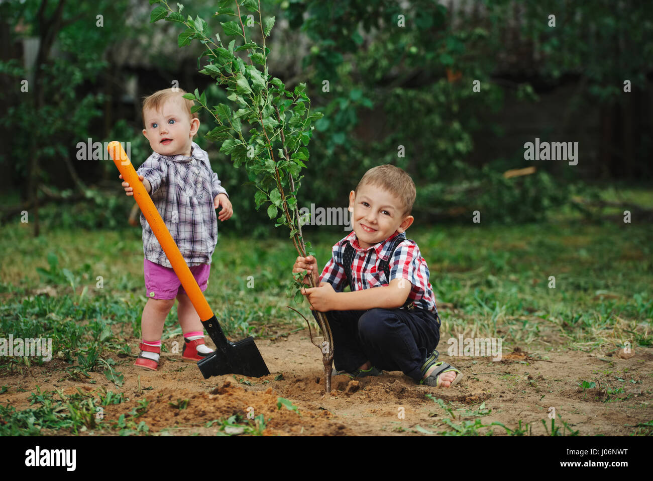little funny boy with shovel in garden Stock Photo - Alamy