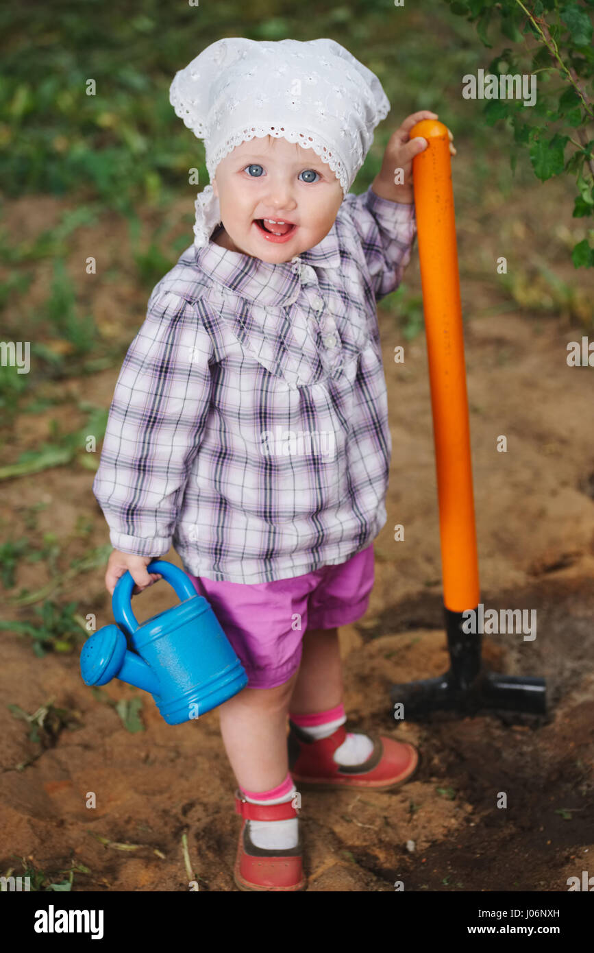 little funny boy with shovel in garden Stock Photo - Alamy