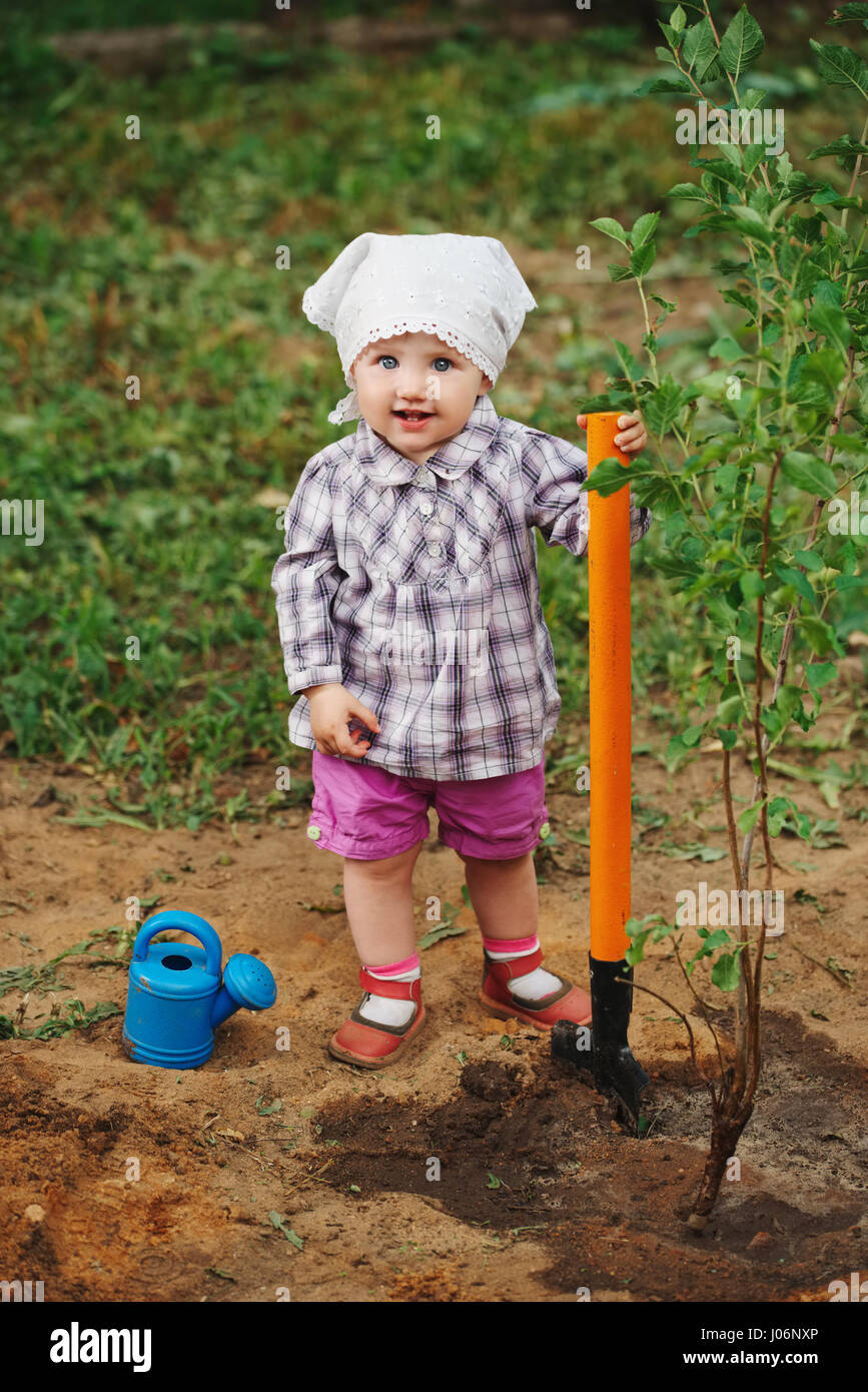 little funny boy with shovel in garden Stock Photo - Alamy