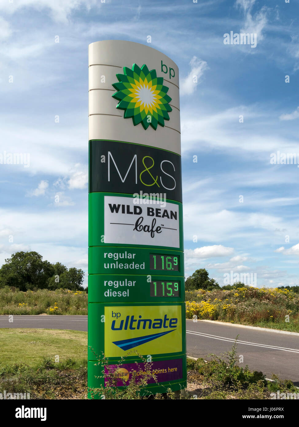 BP M&S Simply Food garage forecourt sign with fuel price display and blue sky behind, Oakham, Rutland, England, UK Stock Photo