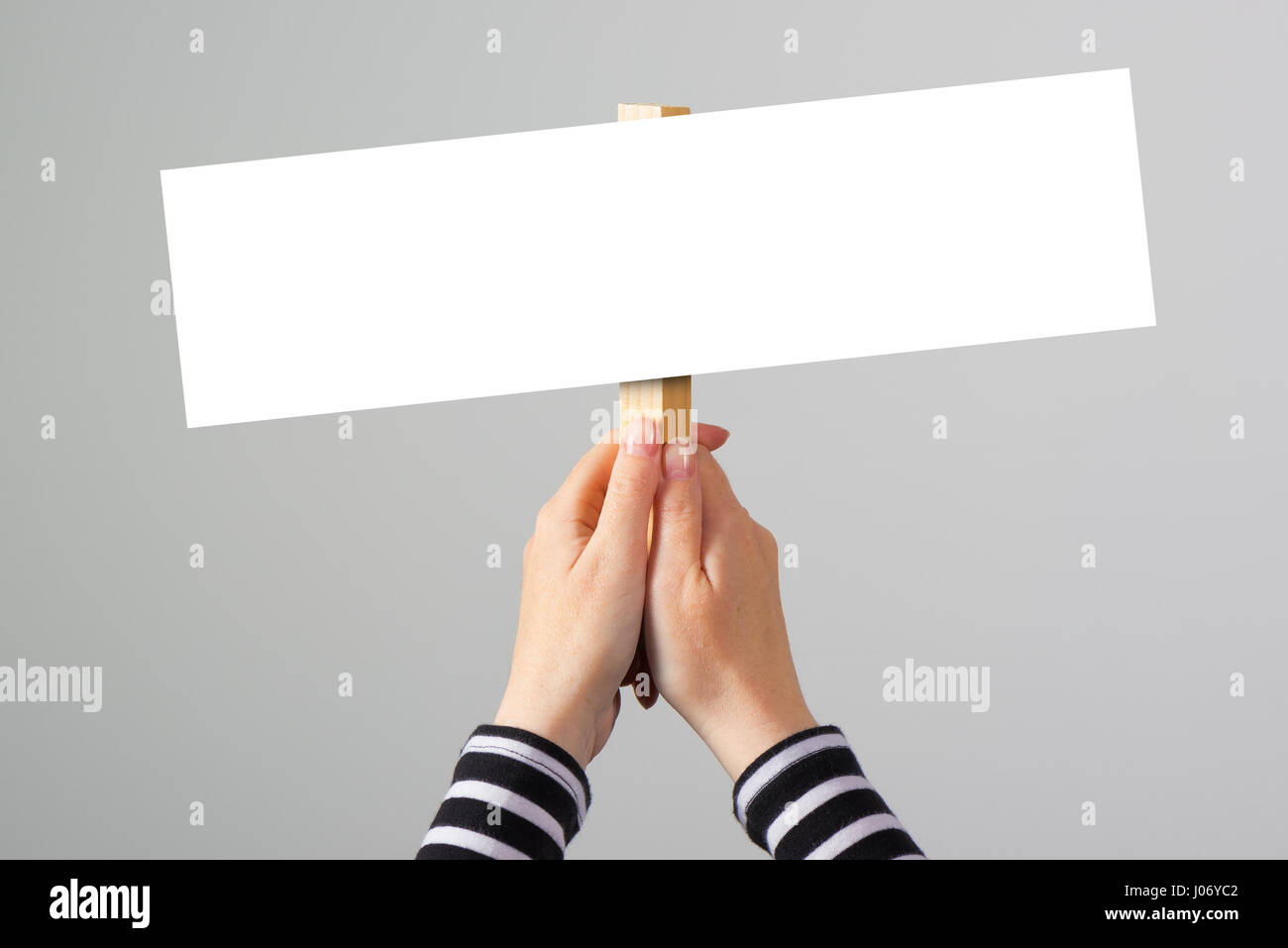 Female hand holding blank mock up banner sign as copy space for quotation text or graphic design Stock Photo