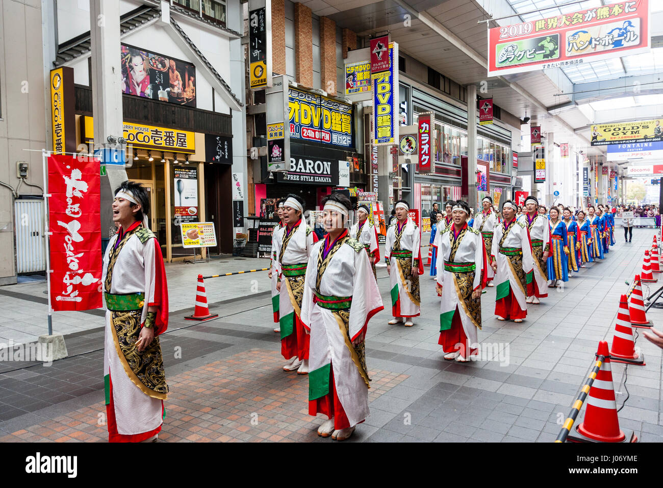 Japan, Kumamoto, Hinokuni Yosakoi dance festival. Dancing team in elaborate yukata and kimono costumes, in 2 lines, standing in shopping mall. Stock Photo