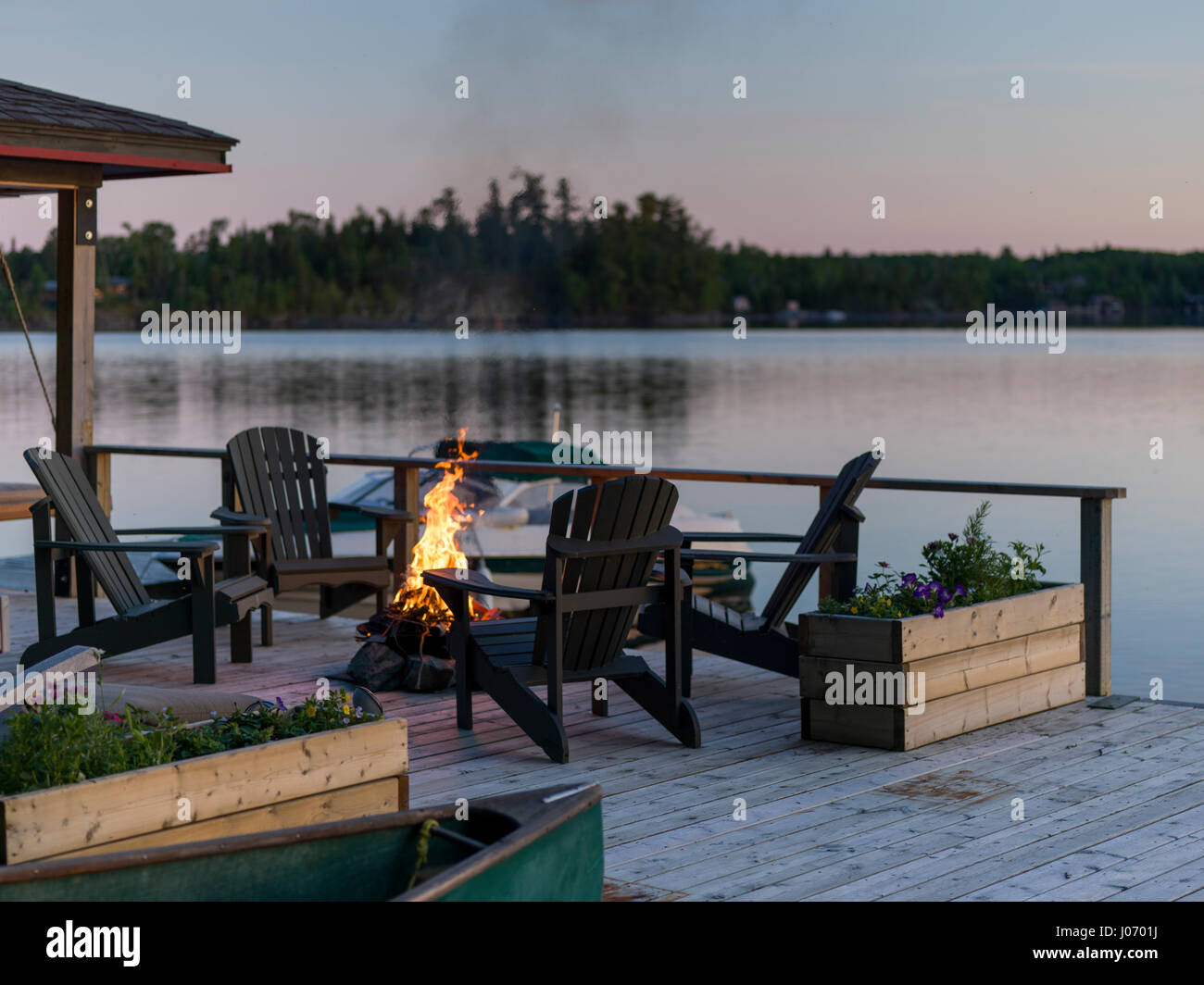 Adirondack chairs and campfire on a dock, Lake of The Woods, Ontario ...