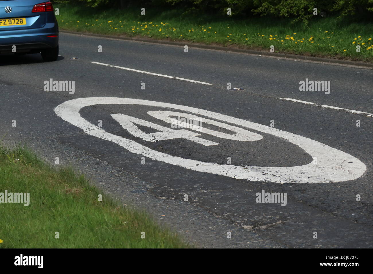 car driving past 40mph speed limit painted on on single carriage