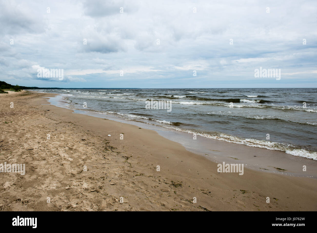 Rocky beach with clouds and water Stock Photo - Alamy