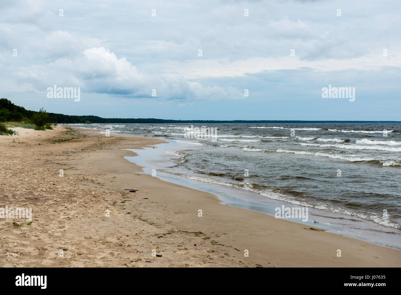Rocky beach with clouds and water Stock Photo - Alamy