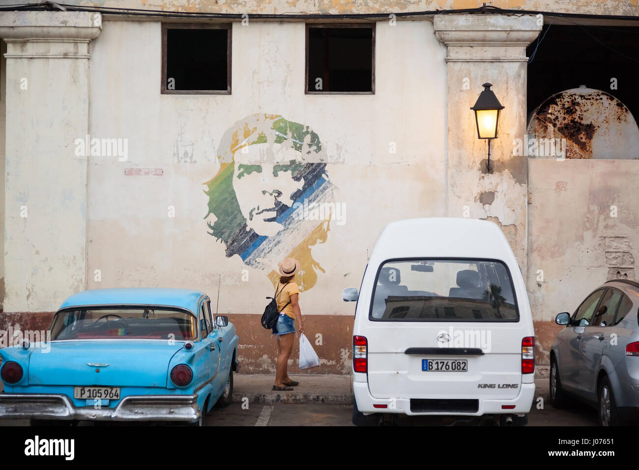 A person looking at Che Guevara graffiti on the side of a building along the Malecon in Old Havana, Cuba. Stock Photo