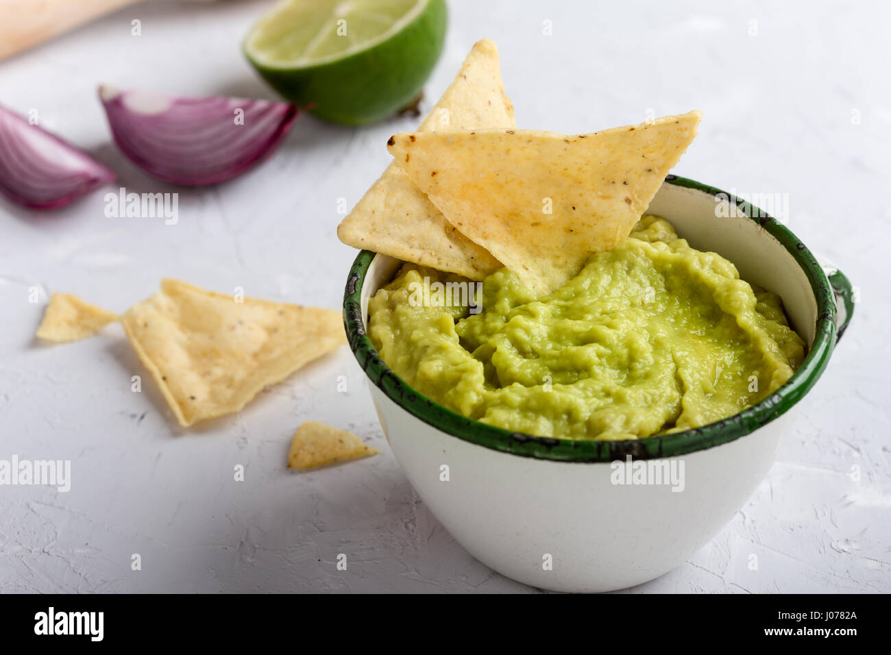 Mexican traditional guacamole in rustic white mug Stock Photo
