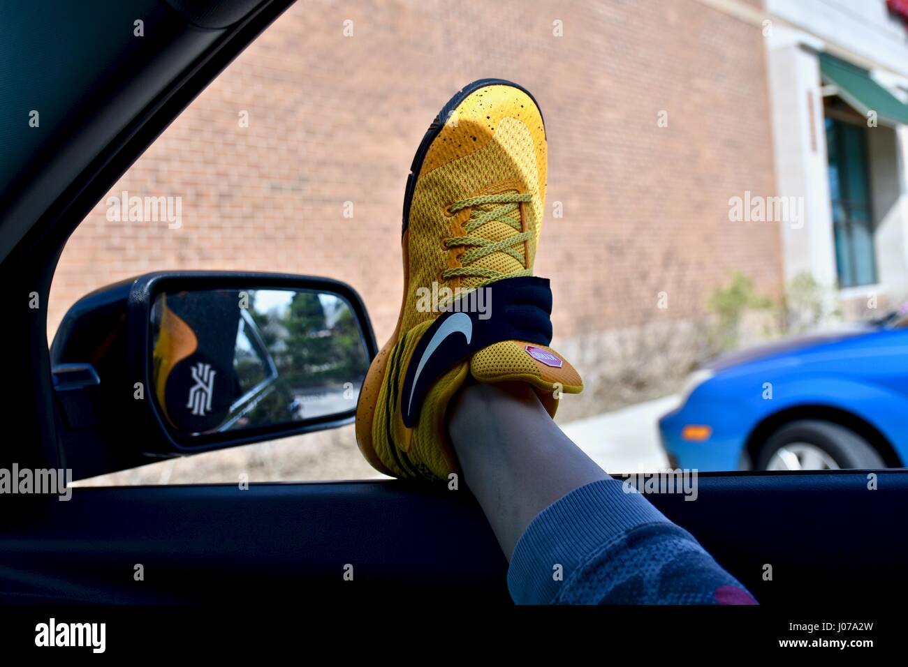 Hanging feet with Nike shoes out car window Stock Photo