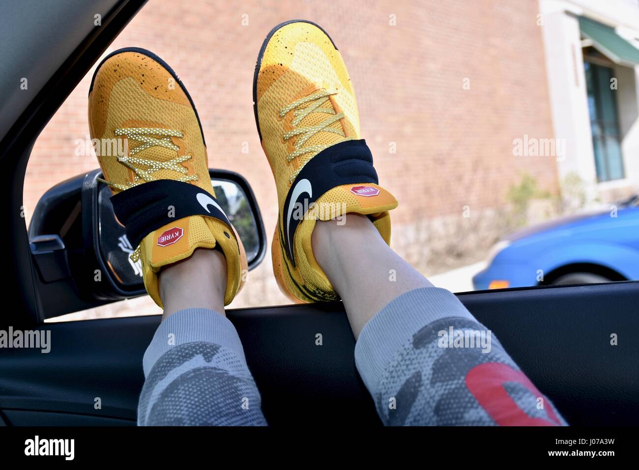Hanging feet with Nike shoes out car window Stock Photo