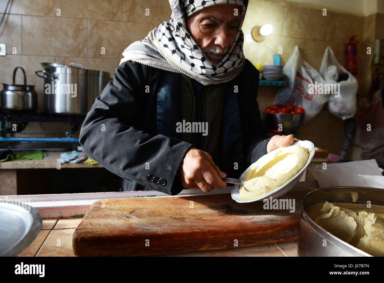 Abu Yousef  preparing delicious Hummus in his small restaurant in Madeba, Jordan. Stock Photo