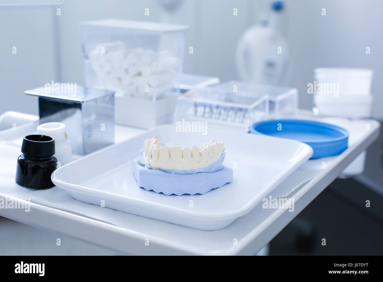 Dental plaster mold with ceramic preparation kit in the background
