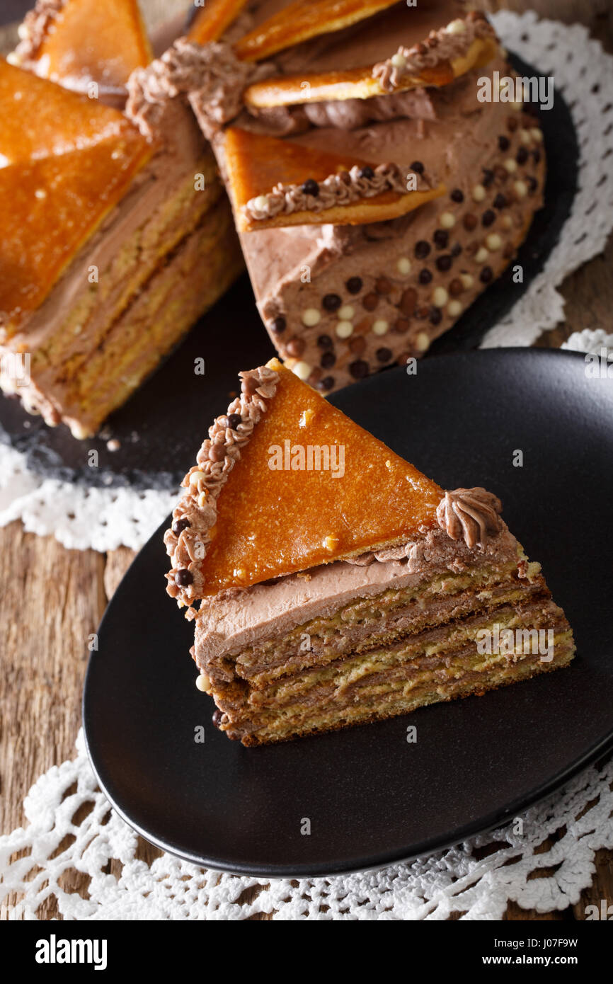 Homemade slice of Hungarian Dobosh cake with caramel close-up on a plate. Vertical Stock Photo