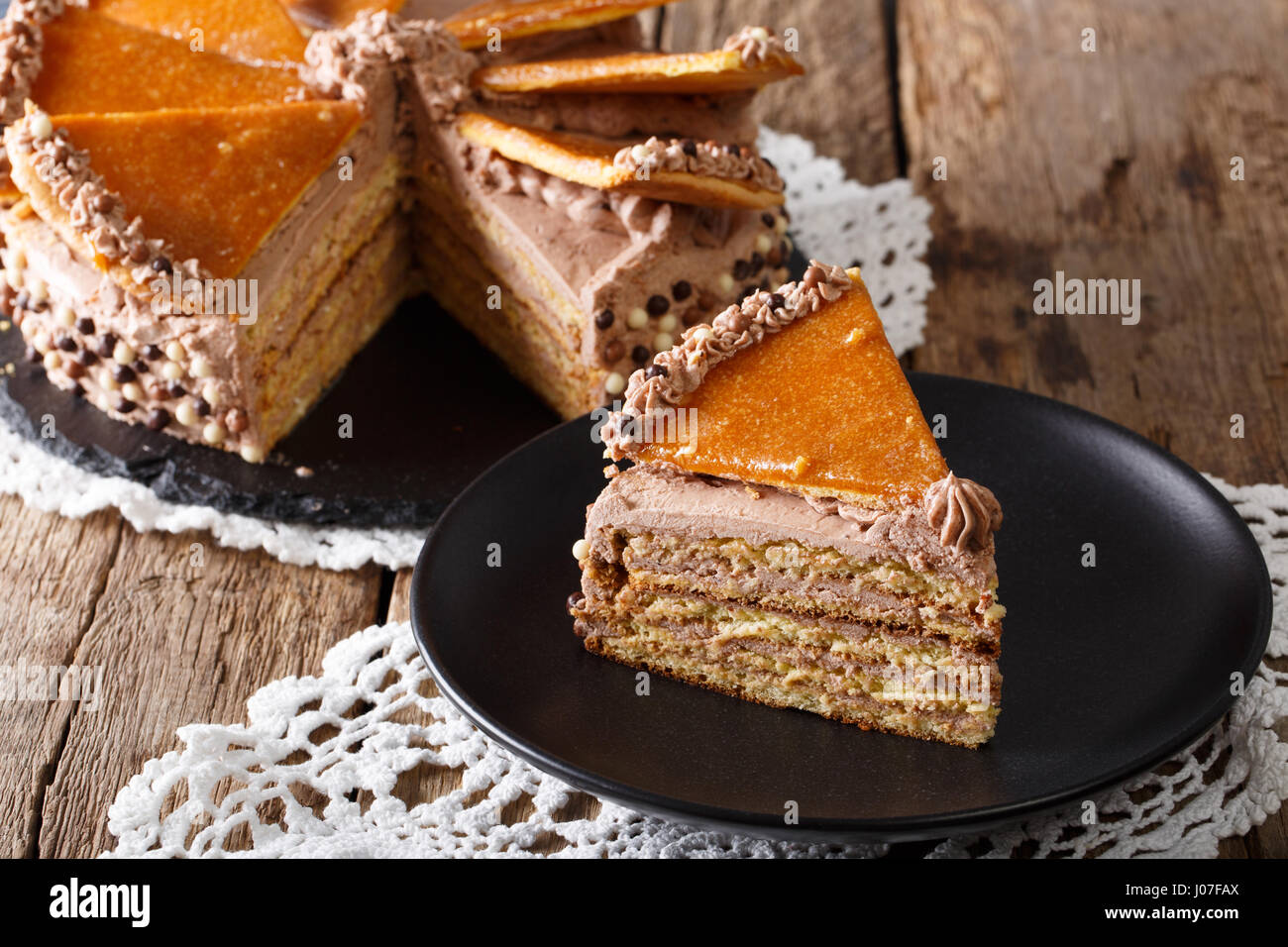 Homemade slice of Hungarian Dobosh cake with caramel close-up on a plate. horizontal Stock Photo