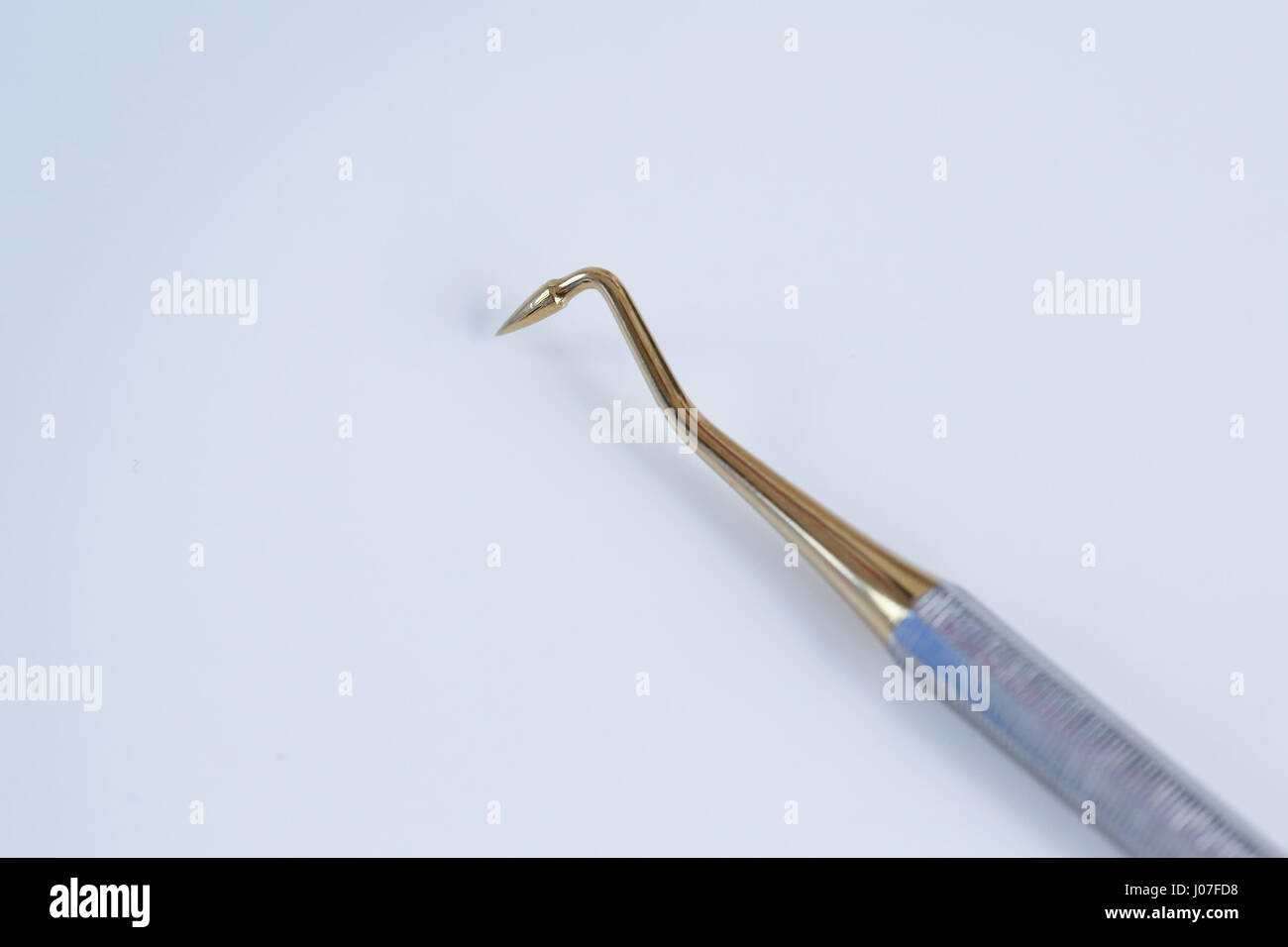 Dental tool - burnisher with golden tapered cone Stock Photo