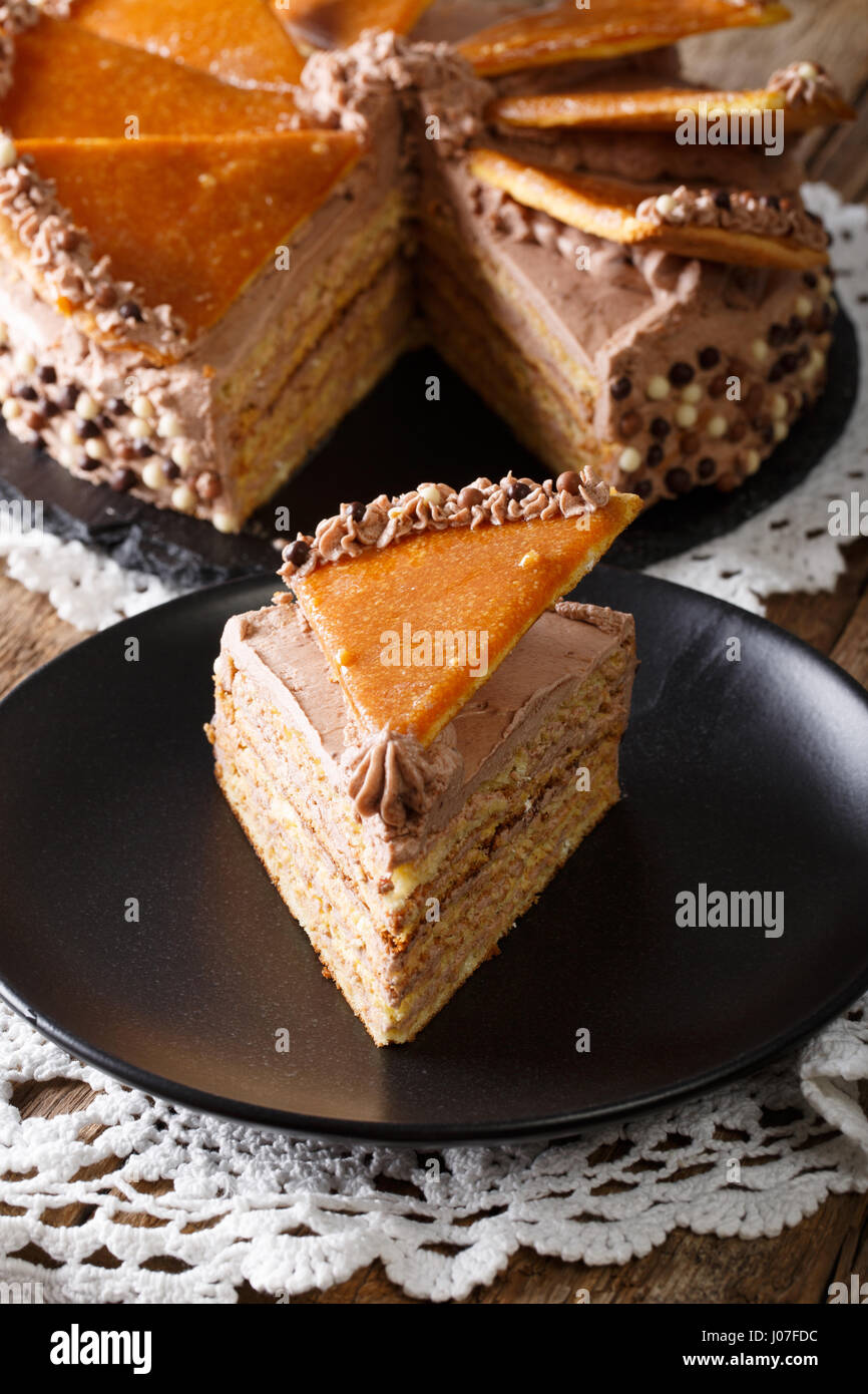 piece of Hungarian Dobos cake with caramel close-up on the table. vertical Stock Photo