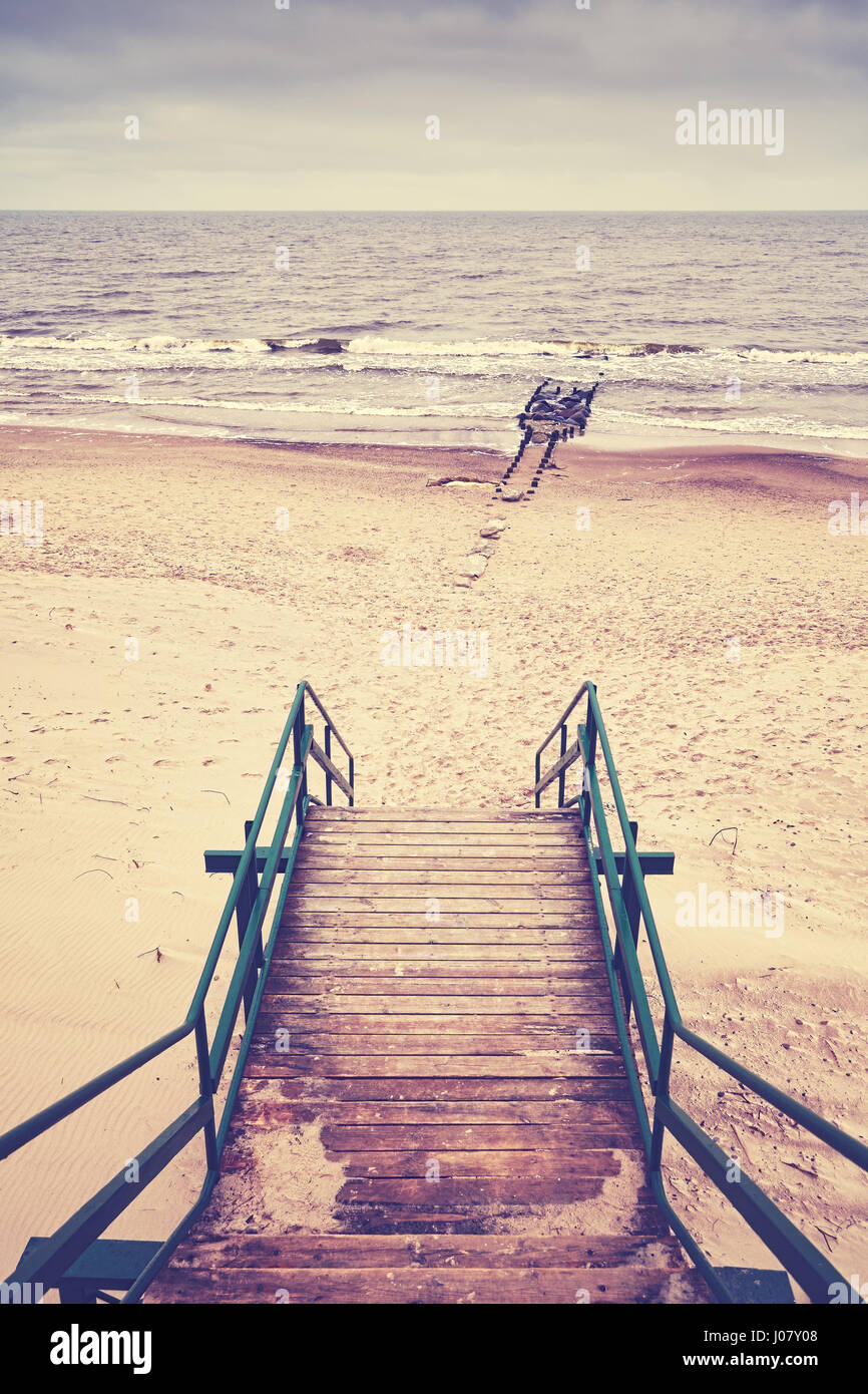 Retro toned picture of stairs on beach, rainy nostalgic mood Stock