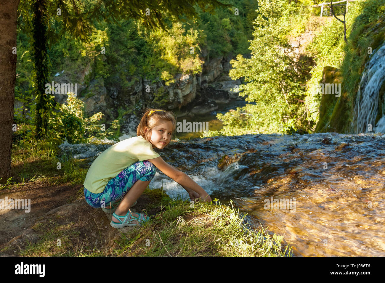 Girl by the waterfall on Slunjcica river flowing into Korana river in Rastoke village near Slunj, Croatia Stock Photo