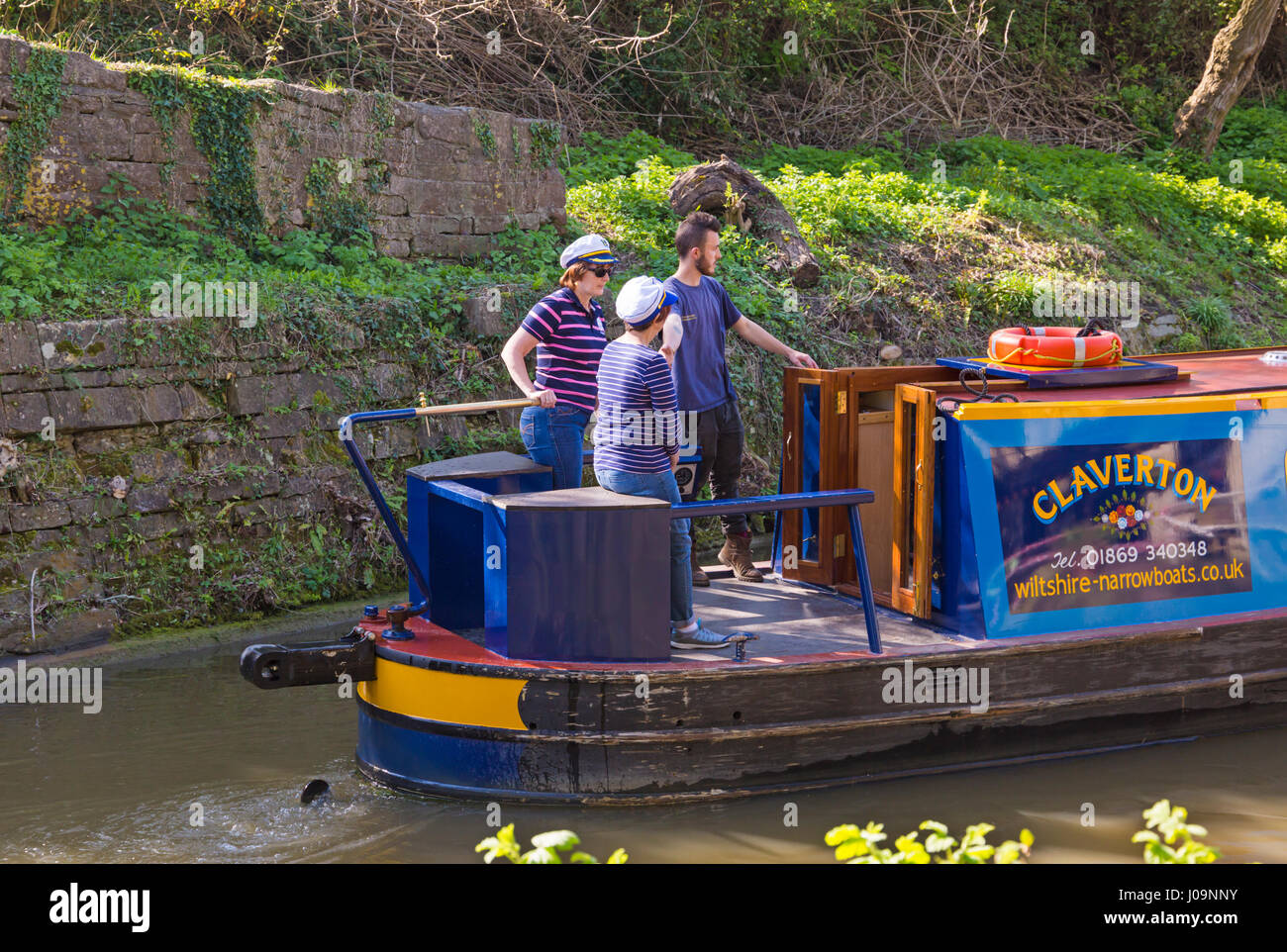 Navigating narrow boat along Kennet and Avon canal at Bradford on Avon, Wiltshire in April Stock Photo
