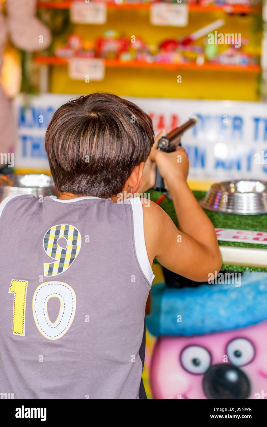 Young boy shooting and having fun in amusement park. Stock Photo