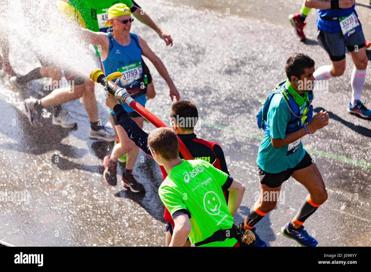 Paris, France - April 09, 2017 : A french firefighter spray water on runners of Paris Marathon 2017 during this sunny day. Stock Photo