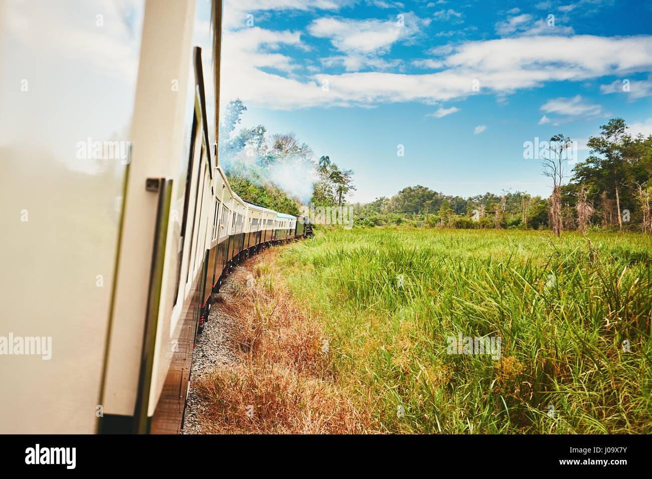 View from window of the steam train passing through countryside in Malaysia. Stock Photo