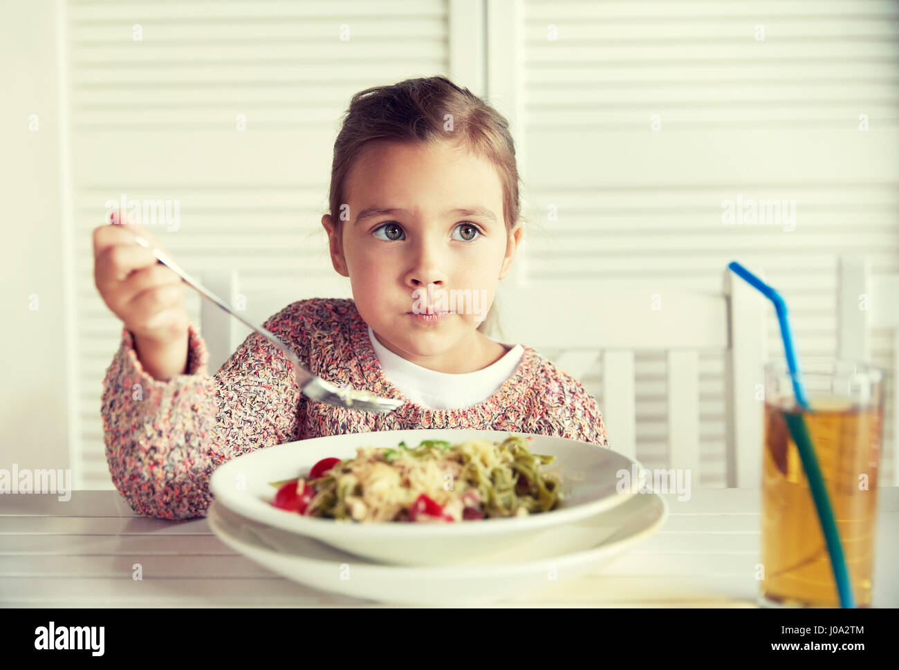 little girl eating pasta for dinner at restaurant Stock Photo