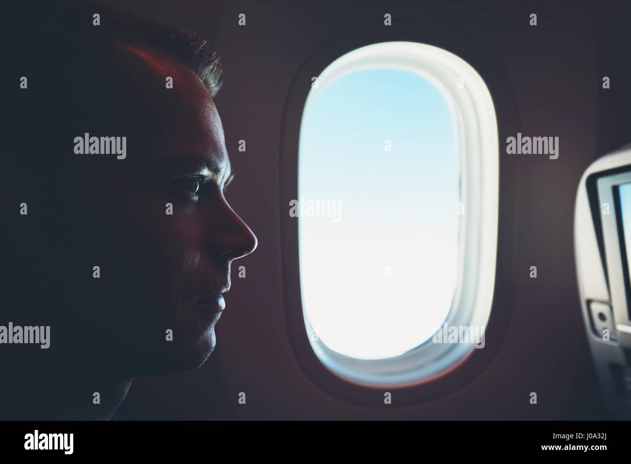 Comfortable traveling by airplane. Silhouette of the passenger enjoying his journey inside an airplane. Stock Photo