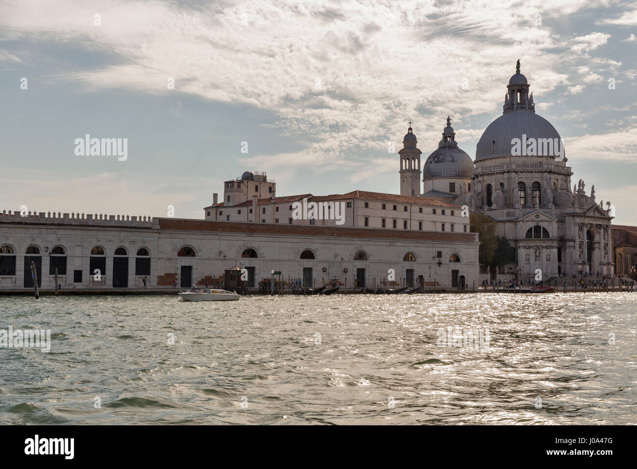 VENICE, ITALY - SEPTEMBER 23, 2016: People visit Basilica Santa Maria della Salute in Dorsoduro district. Venice is one of world most popular tourist  Stock Photo