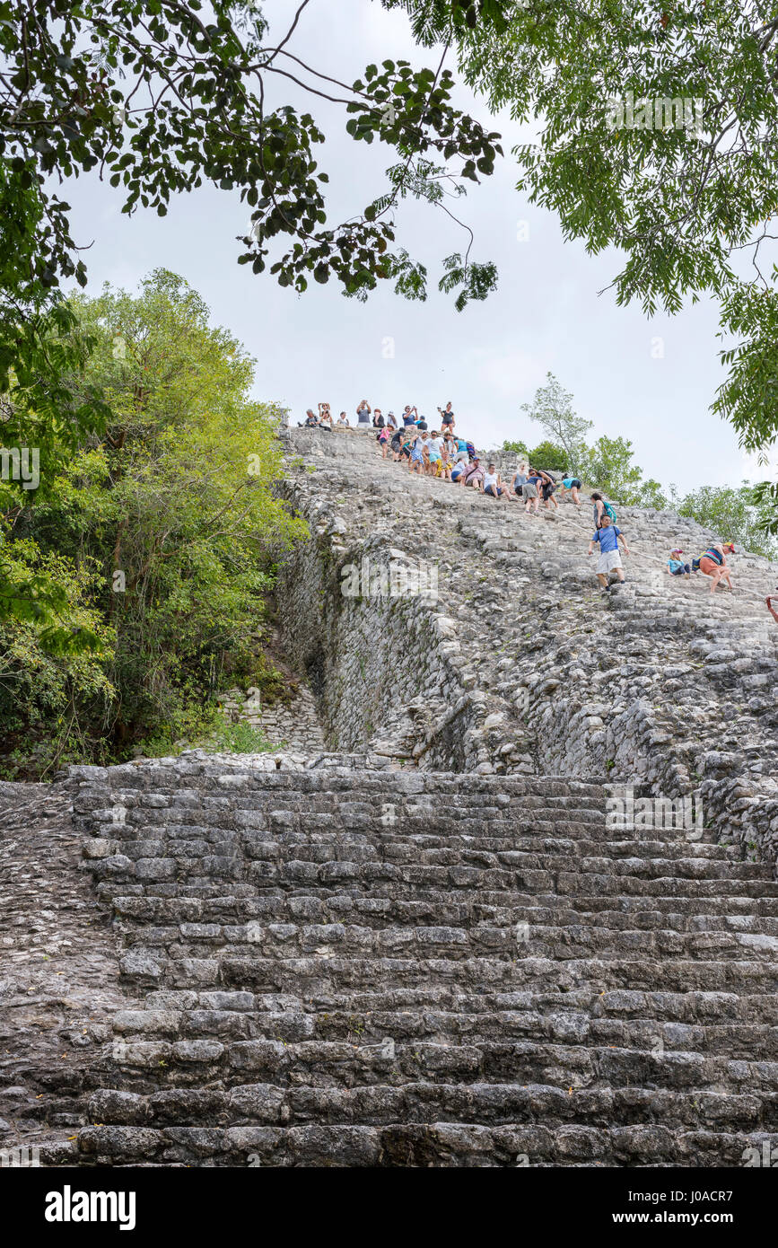 tourists climb the Pyramid Nohoch Mul along the guiding rope at the