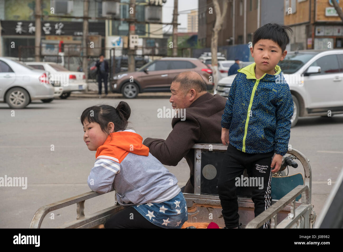 A sister and brother with their grandfather in Xiong County, Hebei