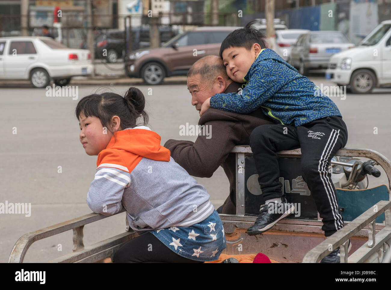 A sister and brother with their grandfather in Xiong County, Hebei