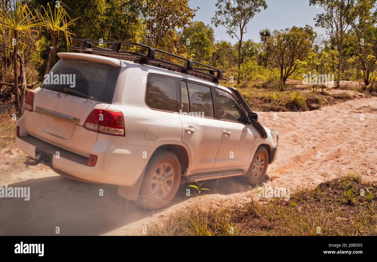 Large offroad vehicle driving through dry riverbed with wheels