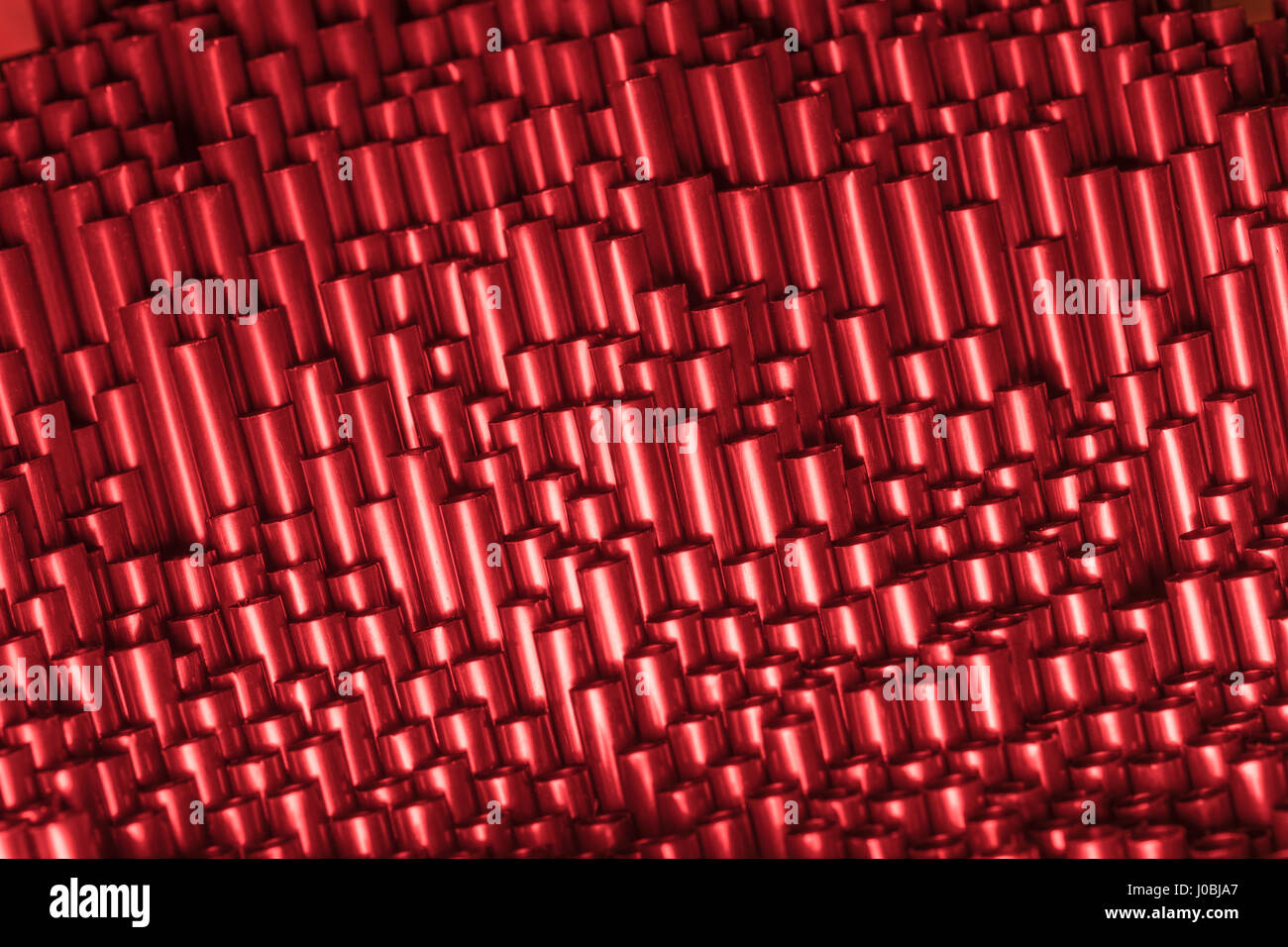 Abstract mass of black plastic drinking straws bathed in red light. Metaphor war on plastic straws, plastic uses, plastics. Abstract plastic texture. Stock Photo