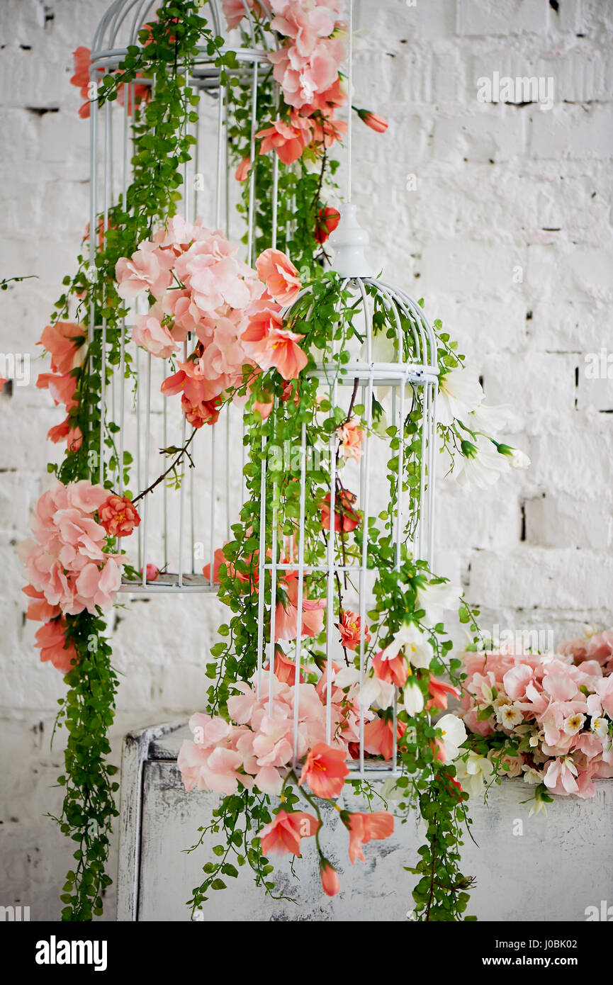 Wedding decor. Cage, entwined with roses and ivy, white and elongated Stock Photo