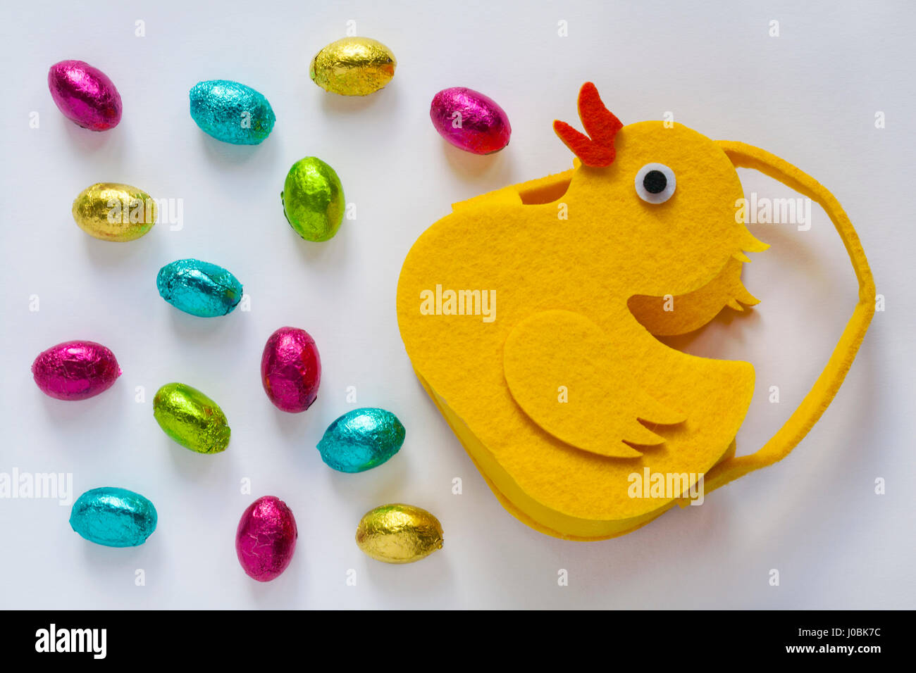 Felt chick with Easter eggs - choccy eggs solid milk chocolate eggs isolated on white background  - ready for Easter Stock Photo