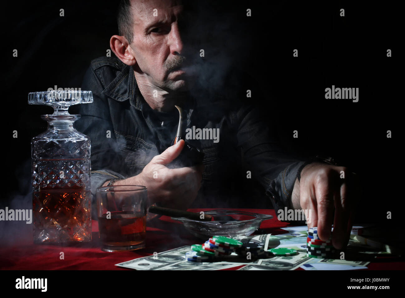 man smoke pipe and play poker Stock Photo Alamy