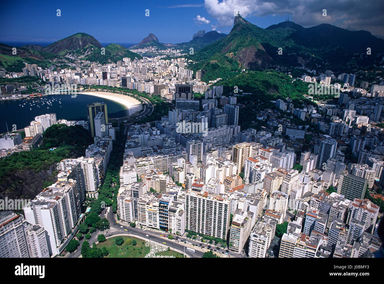 Aerial view of part of Rio de Janeiro south zone - Flamengo quarter in foreground linked to the Enseada de Botafogo ( Botafogo Cove or Botafogo beach ) in the middle by the tree lined Osvaldo Cruz avenue and Christ the Redeemer & the Tijuca Forest in background, Brazil. Stock Photo